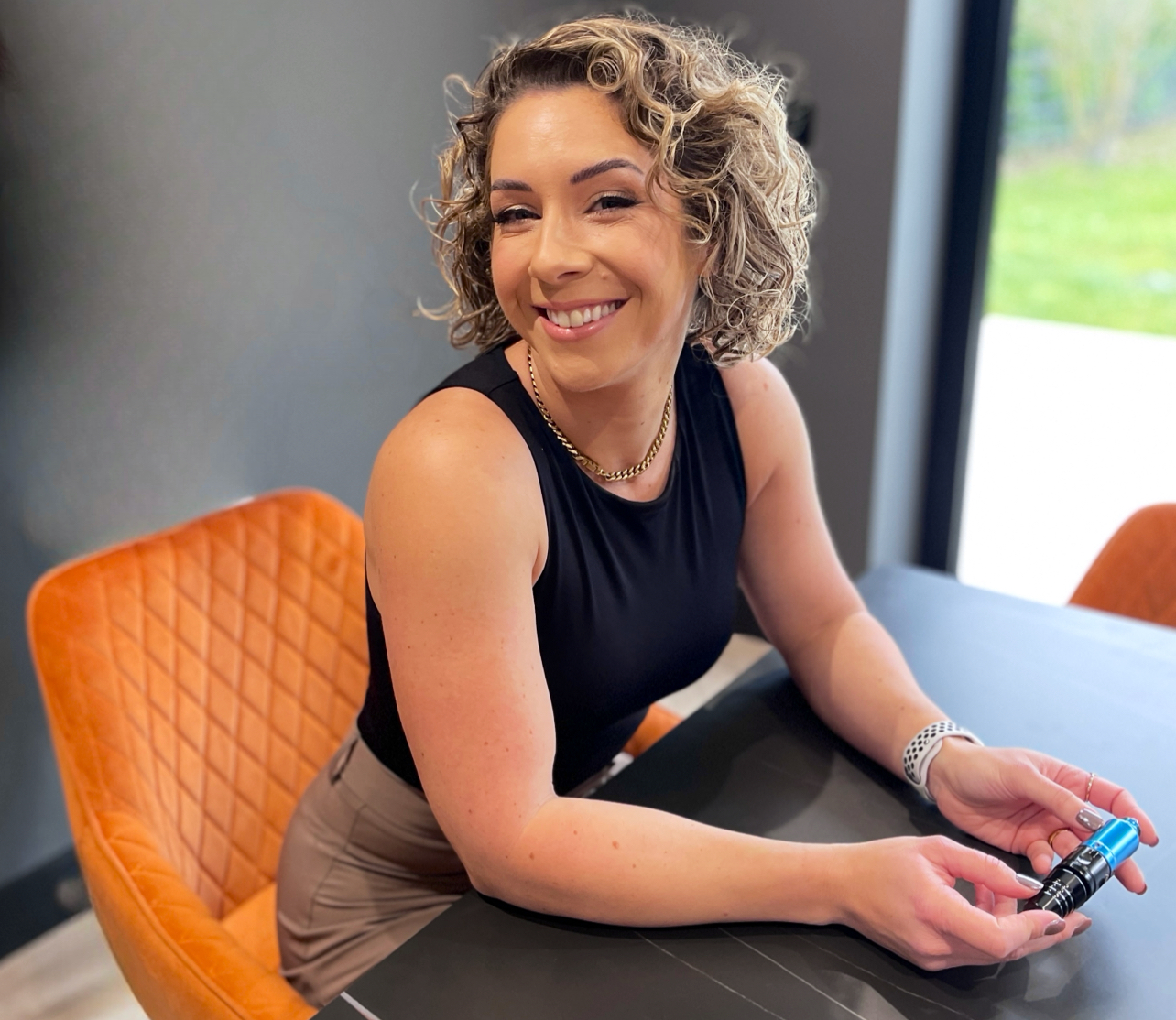 Helen Honey at the studio table, holding her permanent makeup pen