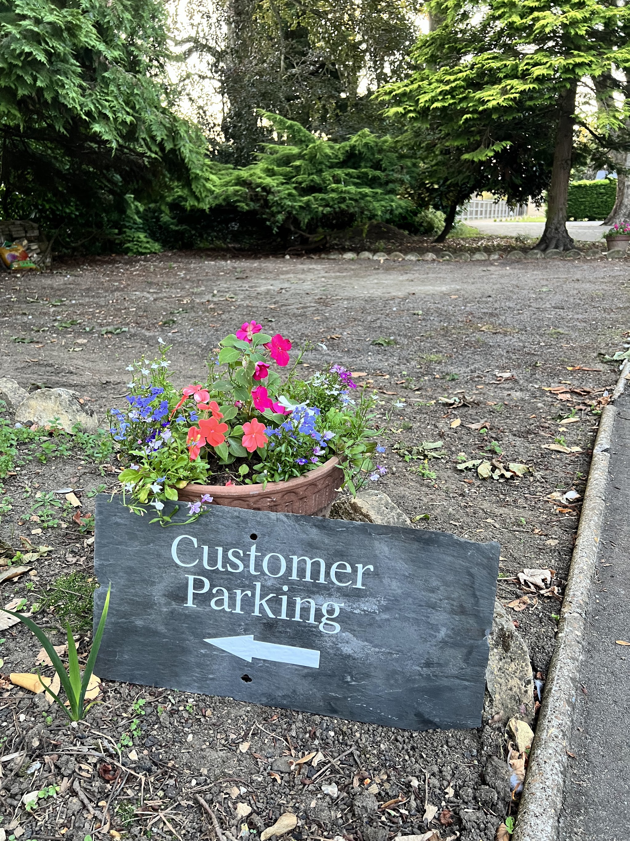 The slate Customer Parking sign on the drive